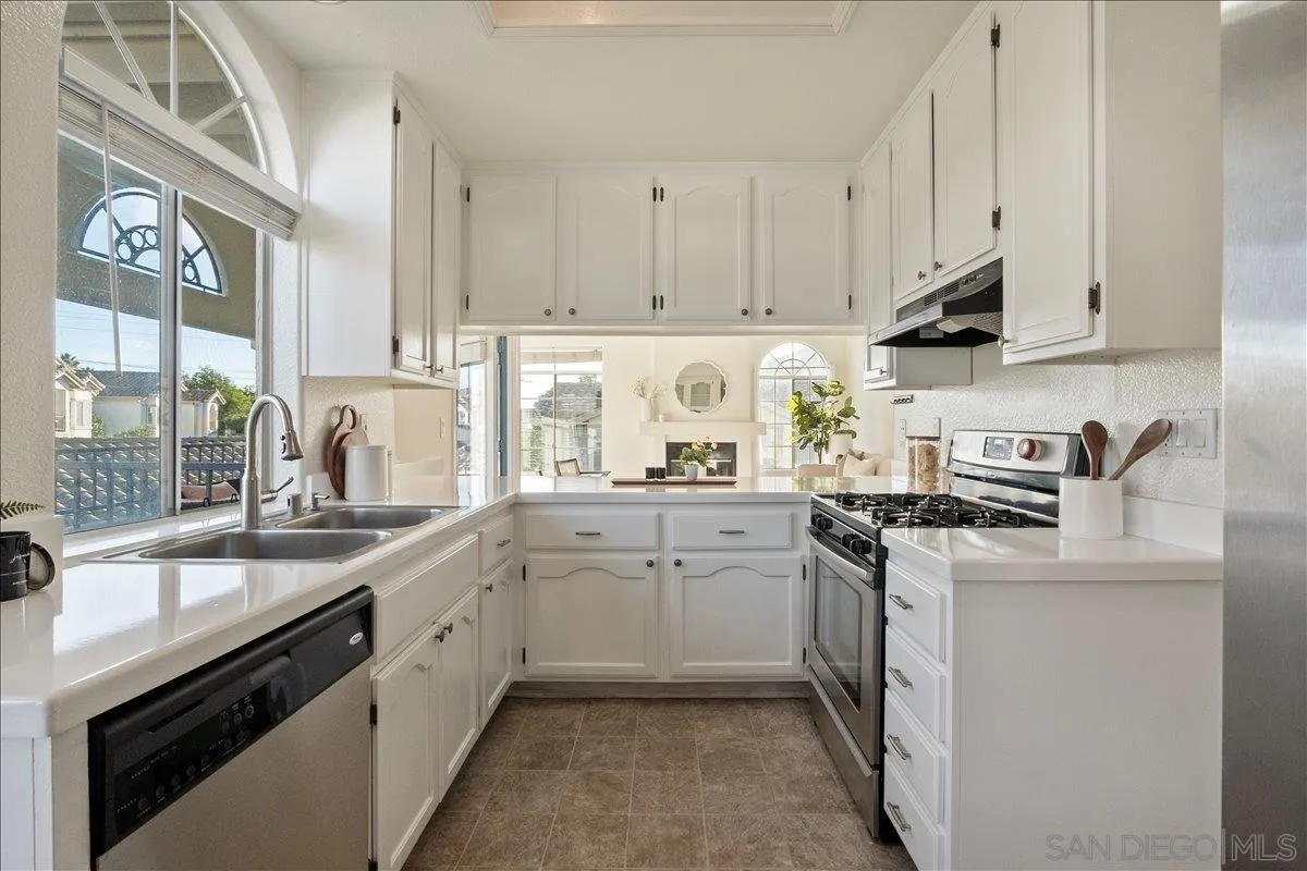 2315 Rancho Del Oro Drive, Unit 14 Oceanside, CA 92056 - Photo 6 of 34 a kitchen with granite countertop a sink stainless steel appliances and cabinets