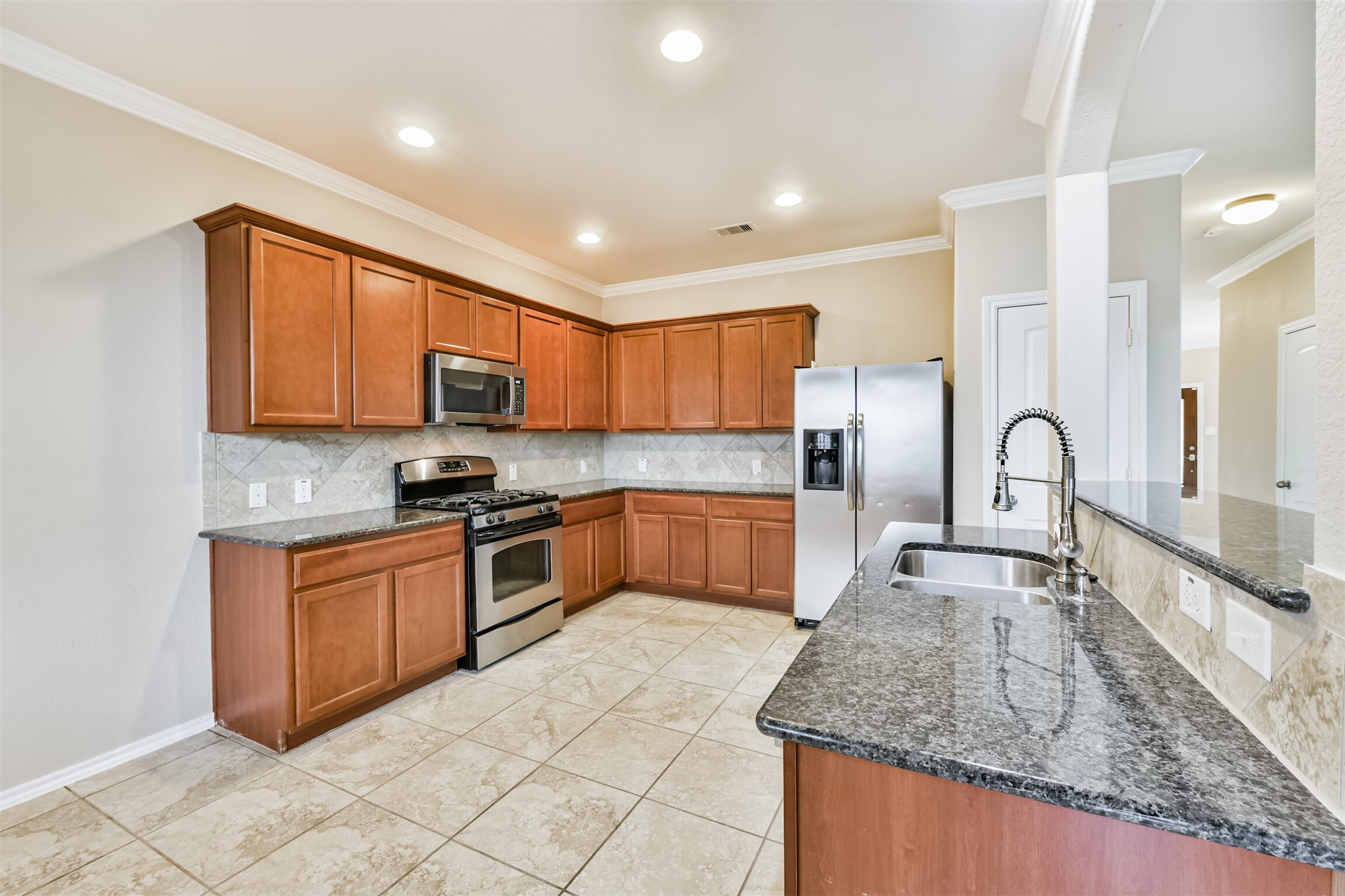 3041 Heather Grove Lane Dickinson, TX 77539 - Photo 11 of 37 a kitchen with stainless steel appliances granite countertop a stove sink and cabinets