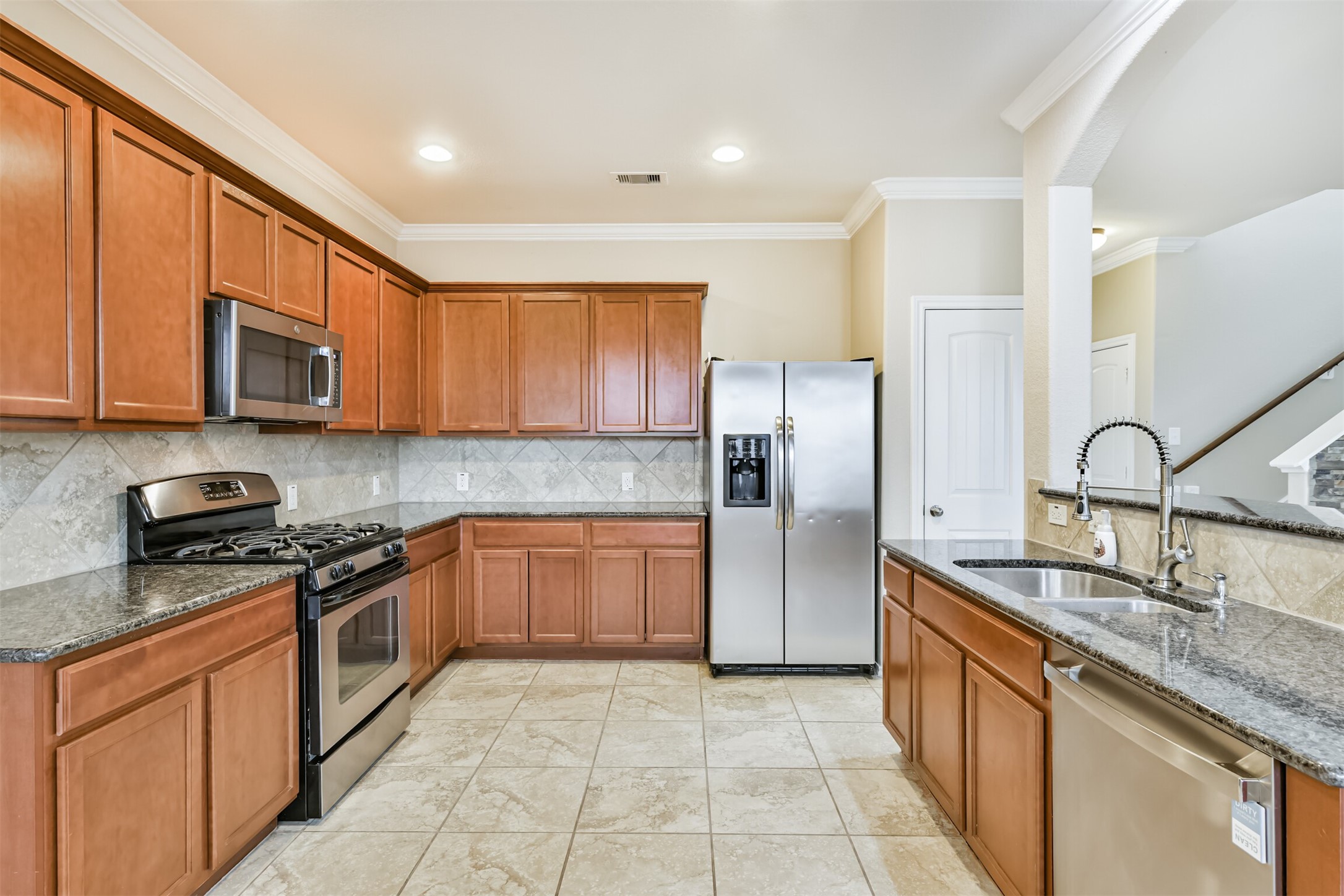 3041 Heather Grove Lane Dickinson, TX 77539 - Photo 12 of 37 a kitchen with stainless steel appliances granite countertop a sink stove microwave and refrigerator