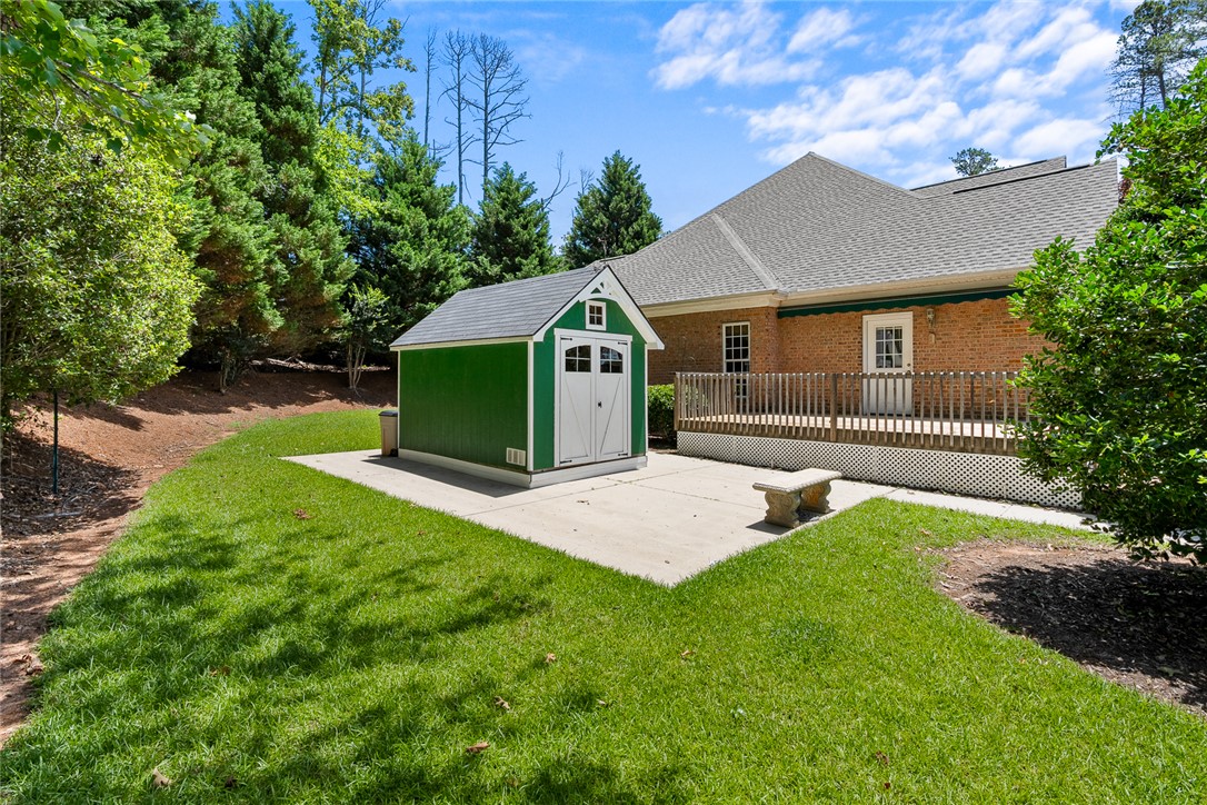 135 Sunset Bay Boulevard Seneca, SC 29672 - Photo 45 of 50 A well-maintained lawn and sturdy storage shed enhance this property's practical outdoor spaces.