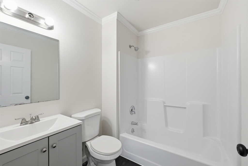 30 Abbey Road, Unit 102 Leominster, MA 01453 - Photo 14 of 15 a bathroom with a toilet a sink a mirror and bathtub