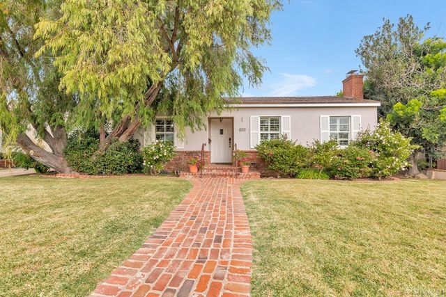 a front view of a house with a yard and trees