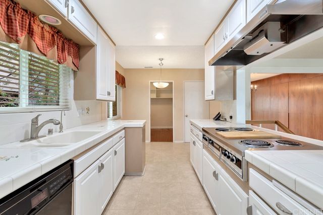 a large kitchen with stainless steel appliances a sink and a stove
