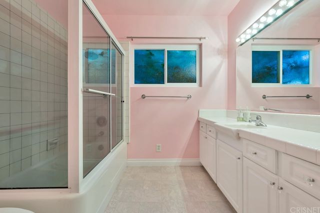 a bathroom with a double vanity sink a mirror and a shower