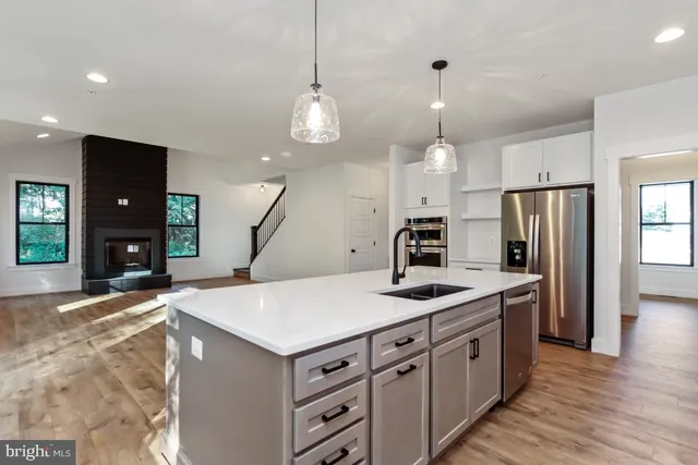 a kitchen with kitchen island a sink stainless steel appliances and a chandelier