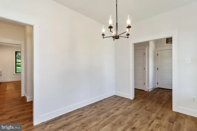 a view of a room with wooden floor and ceiling fan
