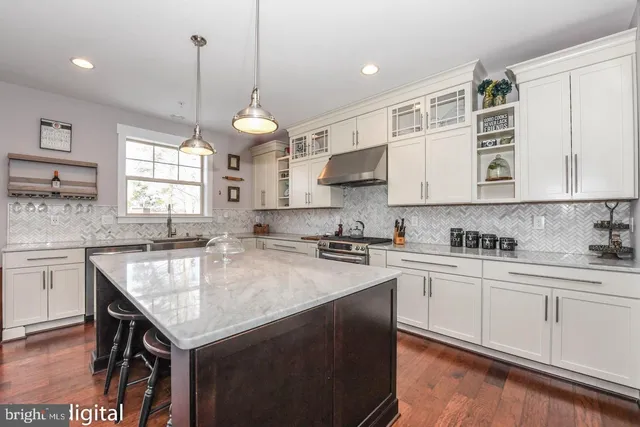 a kitchen with kitchen island granite countertop a sink a stove and cabinets