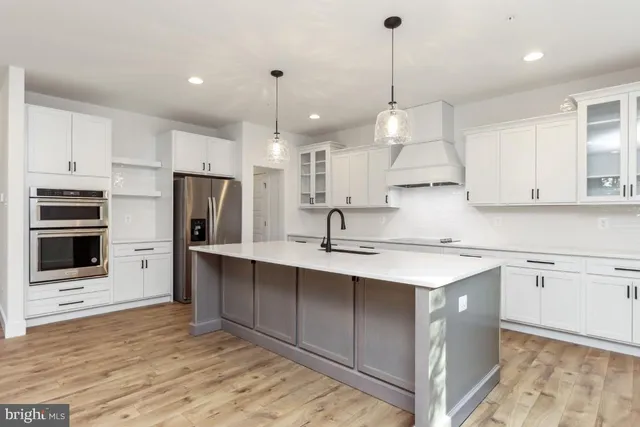 a kitchen with kitchen island a sink stainless steel appliances and cabinets
