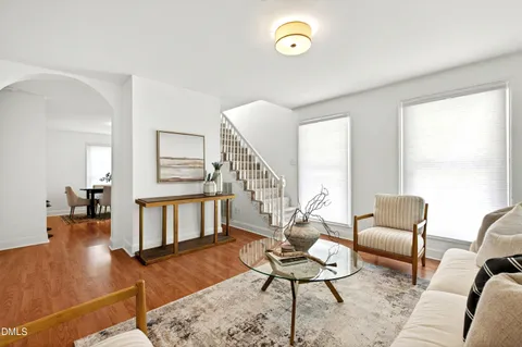 a living room with furniture and a wooden floor