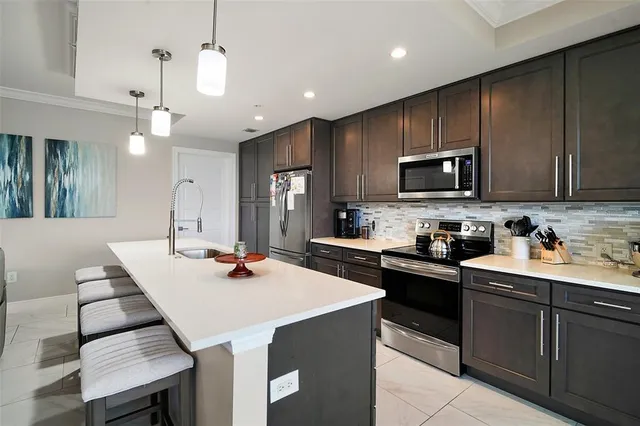a living room with stainless steel appliances kitchen island granite countertop furniture and a large window