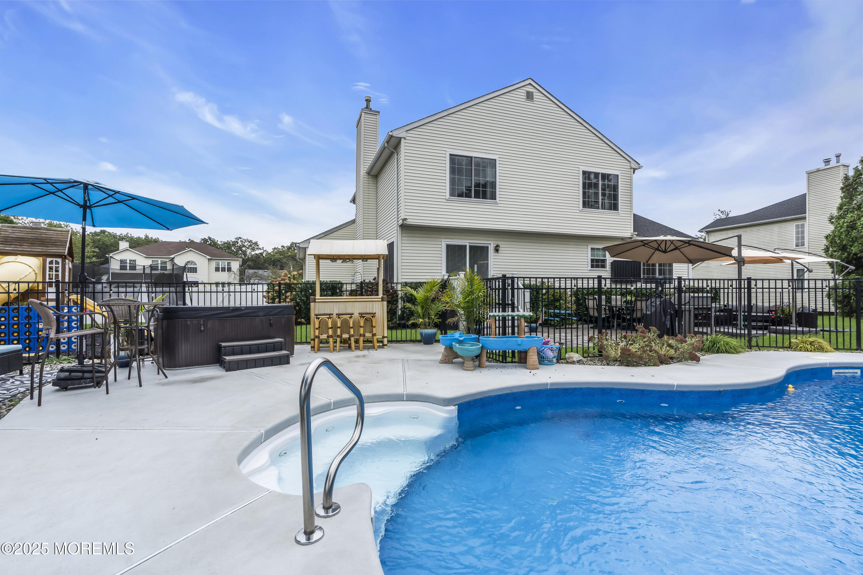 4 Rainbow Drive Howell, NJ 07731 - Photo 2 of 38 a view of a swimming pool with lawn chairs under an umbrella