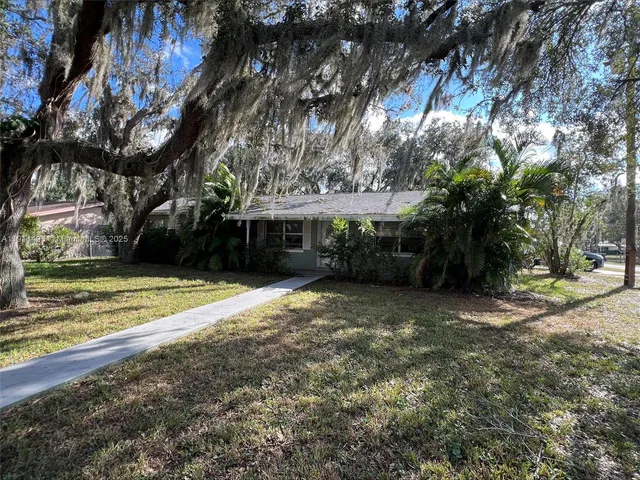 a view of a house with a yard and tree s