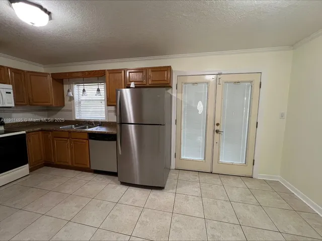 a kitchen with a refrigerator a stove and cabinets