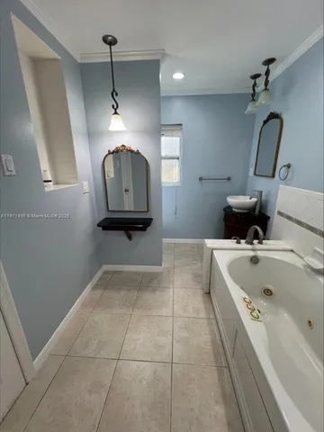 a bathroom with a tub sink and mirror