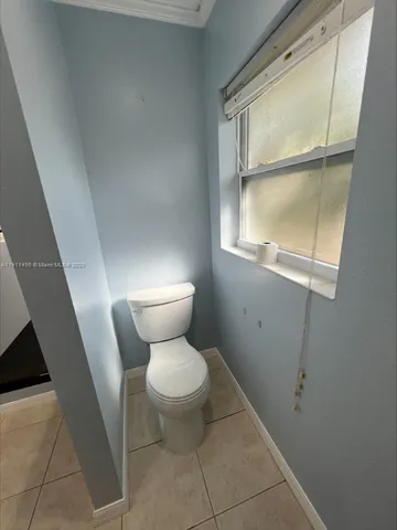 a white toilet sitting next to a window