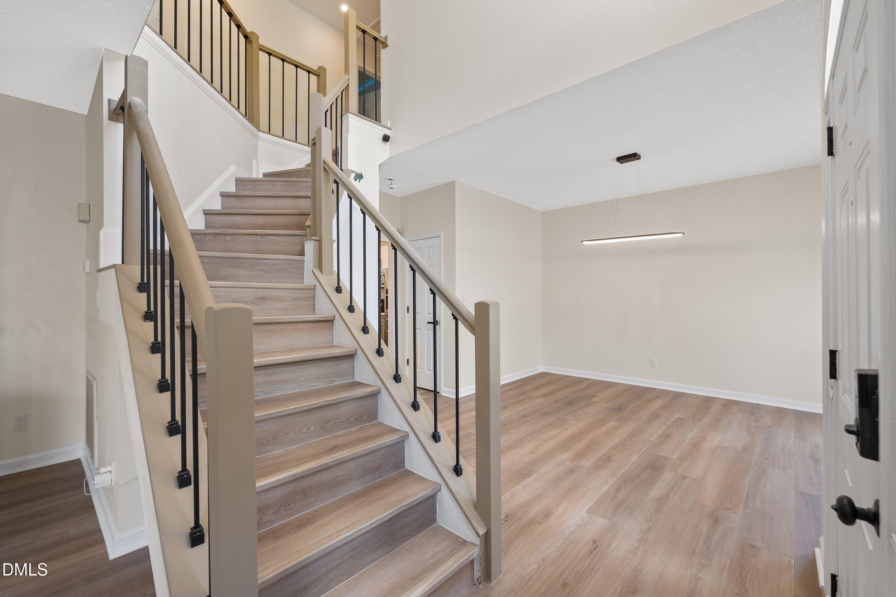 2517 Birchford Court Raleigh, NC 27604 - Photo 7 of 63 a view of staircase with wooden floor and white walls