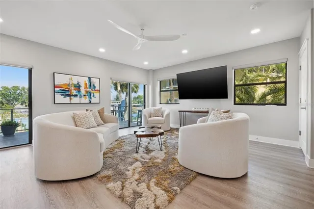a view of hallway with wooden floor and a bathroom