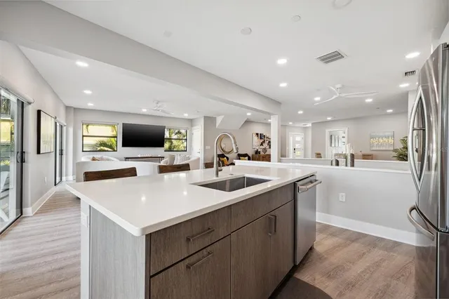 a kitchen with stainless steel appliances kitchen island granite countertop a table chairs microwave and sink