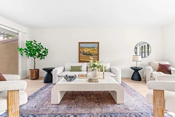a living room with furniture flowerpot and wooden floor