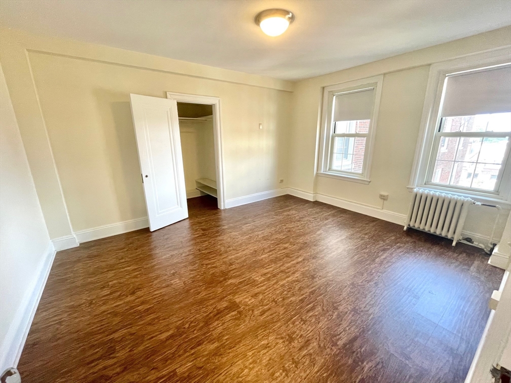 1401 Beacon Street, Unit 704 Brookline, MA 02446 - Photo 5 of 11 an empty room with wooden floor and windows