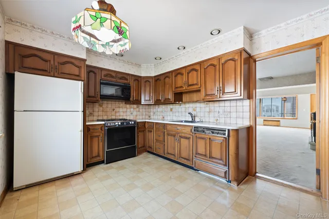 a kitchen with stainless steel appliances granite countertop a refrigerator a stove and a sink