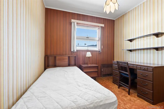 a bedroom with a bed and a dresser in it