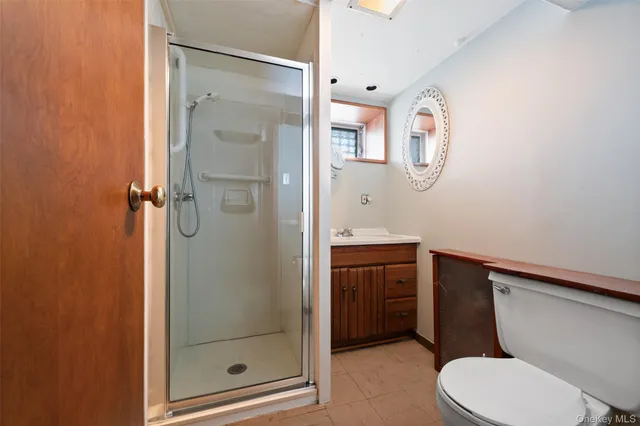 a bathroom with a toilet shower vanity and a sink