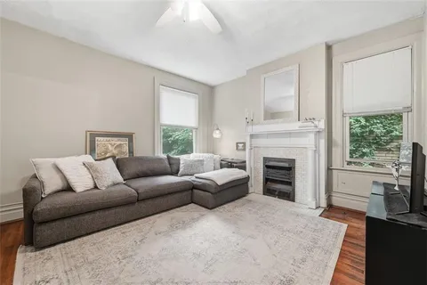 a living room with furniture a fireplace and a large window