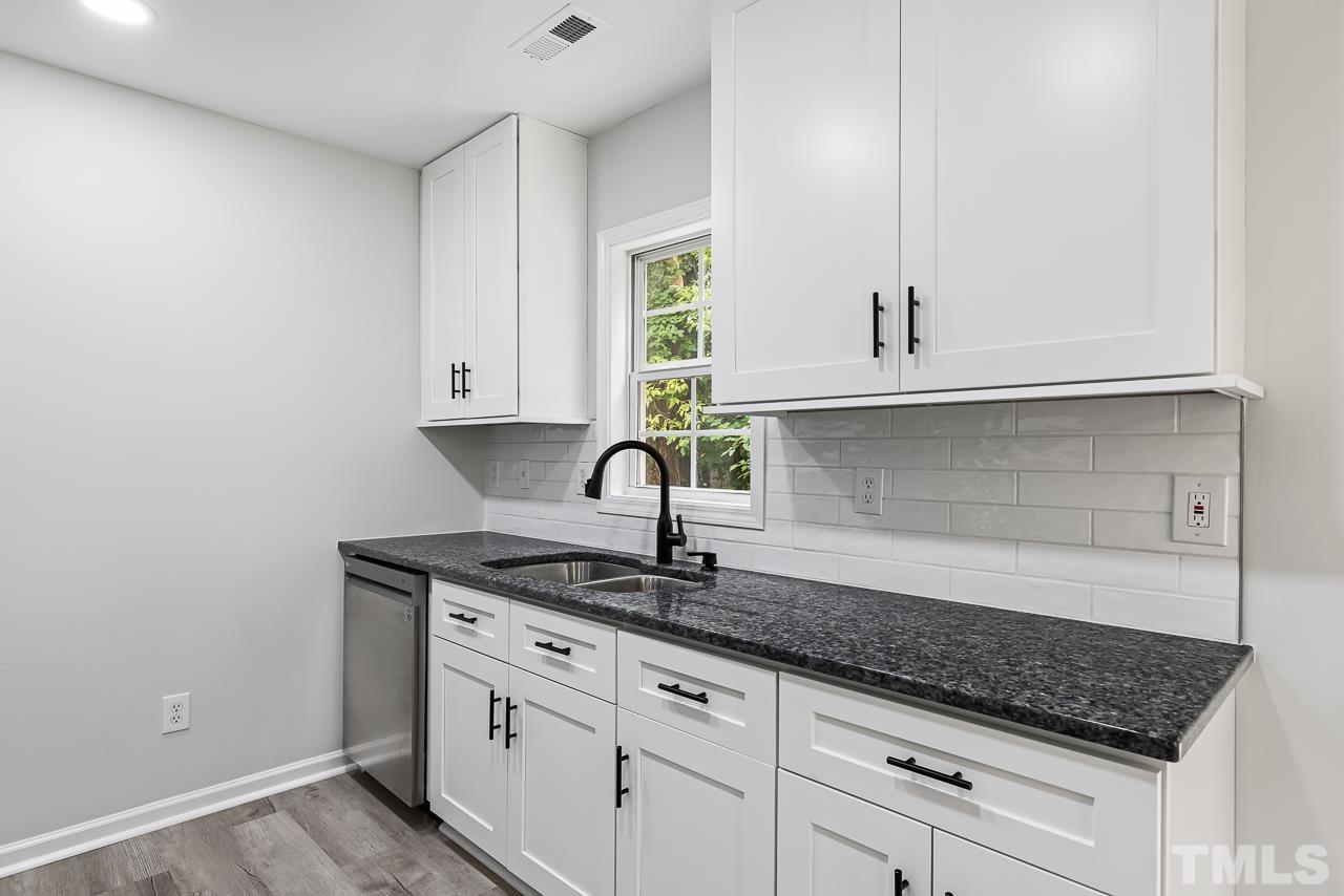 704 Hartford Road Raleigh, NC 27610 - Photo 13 of 29 a kitchen with granite countertop white cabinets and a sink