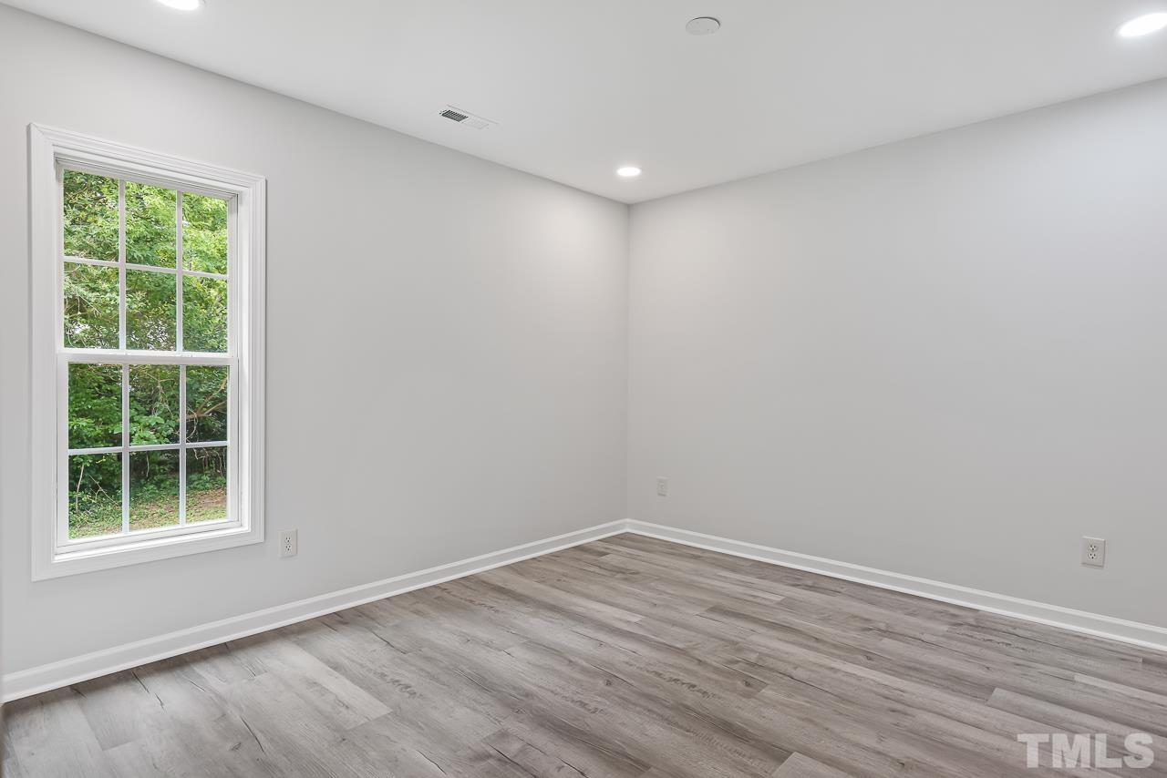 704 Hartford Road Raleigh, NC 27610 - Photo 15 of 29 a view of empty room with wooden floor and fan