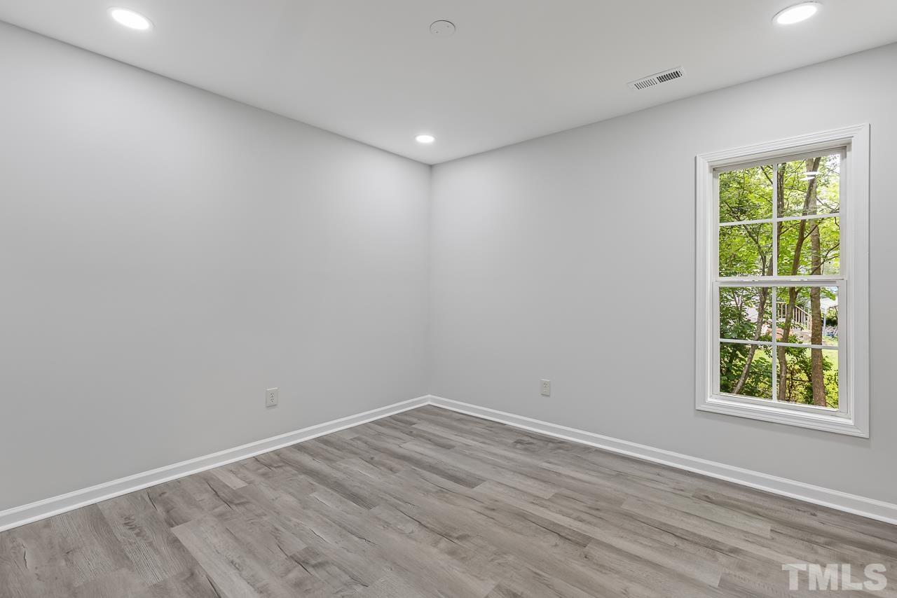 704 Hartford Road Raleigh, NC 27610 - Photo 21 of 29 wooden floor in an empty room with a window