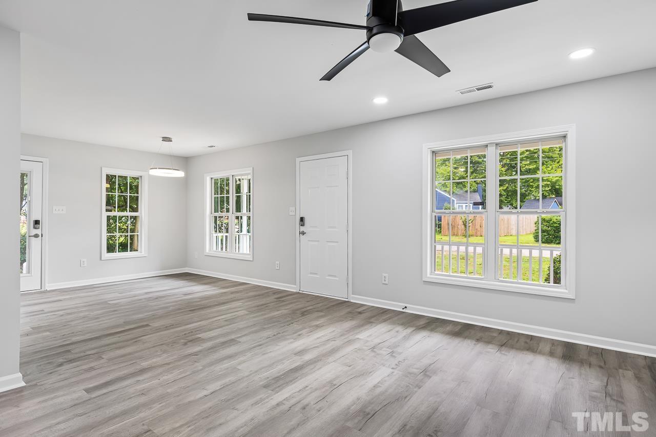 704 Hartford Road Raleigh, NC 27610 - Photo 7 of 29 a view of an empty room with a window and wooden floor