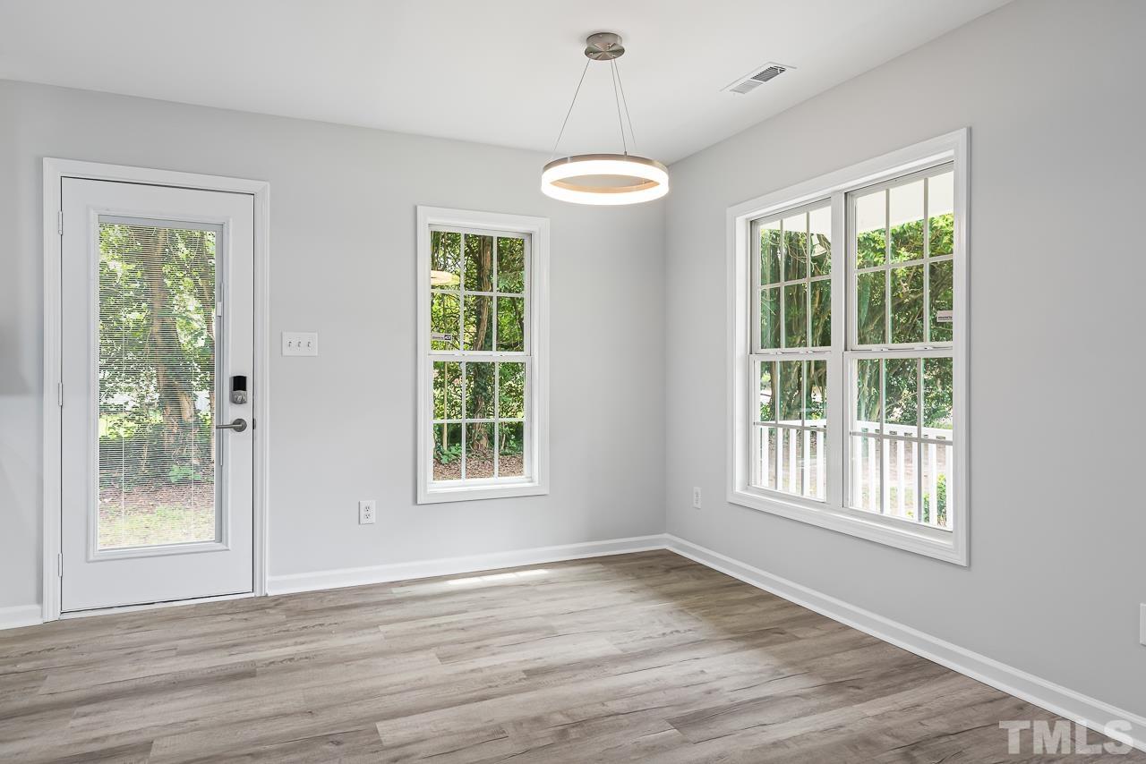 704 Hartford Road Raleigh, NC 27610 - Photo 10 of 29 a view of an empty room with a window and wooden floor