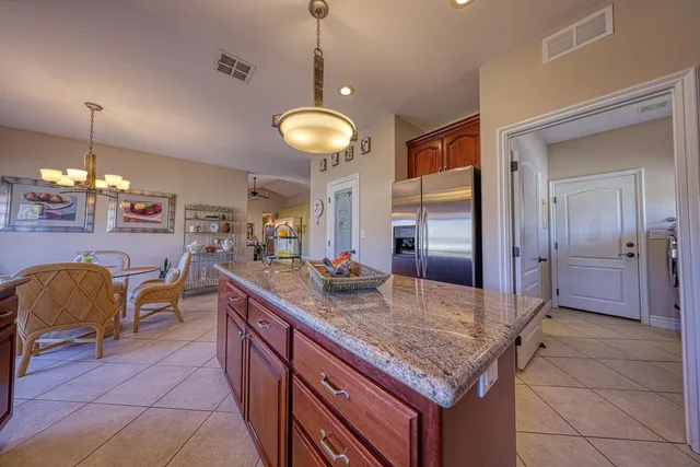 a kitchen with stainless steel appliances granite countertop a sink counter space and living room view