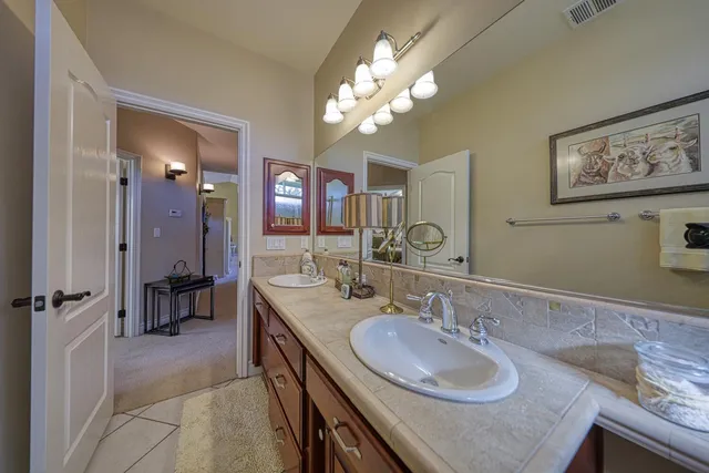 a bathroom with a granite countertop sink a large mirror and a shower
