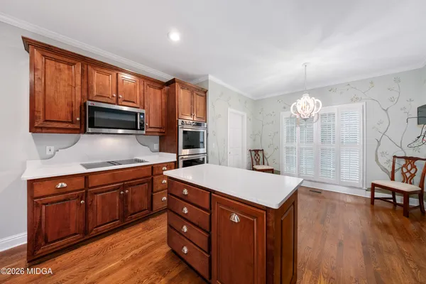a kitchen with stainless steel appliances granite countertop a stove a sink dishwasher and a microwave oven with wooden floor
