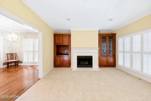 a view of an empty room with a fireplace and a window