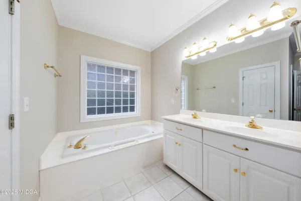 a spacious bathroom with a tub a sink and mirror