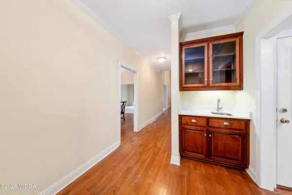 a hallway with wooden floor and cabinet