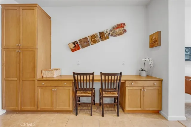 a kitchen with stainless steel appliances kitchen island granite countertop a refrigerator a stove a sink a dining table and chairs with wooden floor