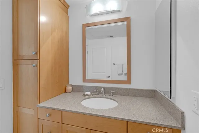 a en suite bathroom with a granite countertop sink and a mirror