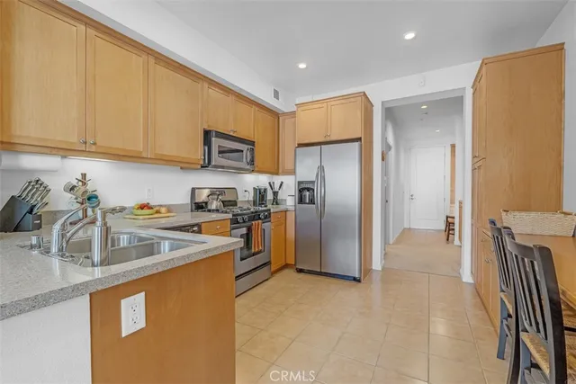 a kitchen with stainless steel appliances granite countertop a refrigerator and a stove top oven