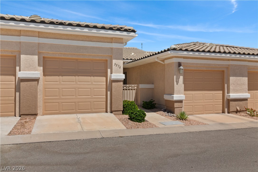 3376 Partridge Run Street Laughlin, NV 89029 - Photo 52 of 92 A well-maintained facade features stucco exteriors and prominent garage doors, offering convenient access.