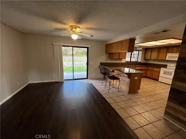 a living room with a table chairs and a kitchen view