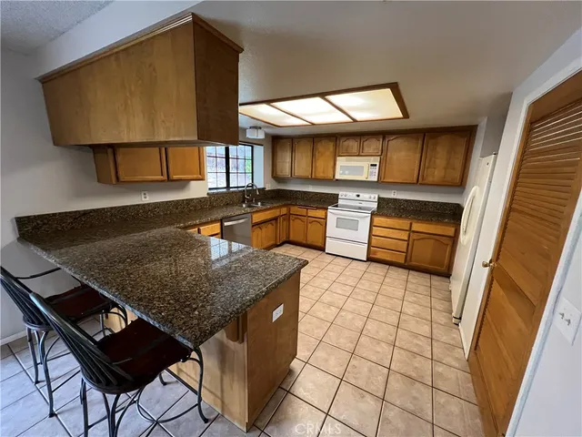a kitchen with stainless steel appliances granite countertop a sink and a stove