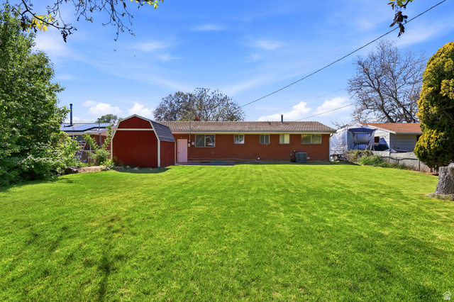 2348 North 770 West Clinton, UT 84015 - Photo 17 of 25 Expansive green lawn with a red barn-style shed, providing ample outdoor space