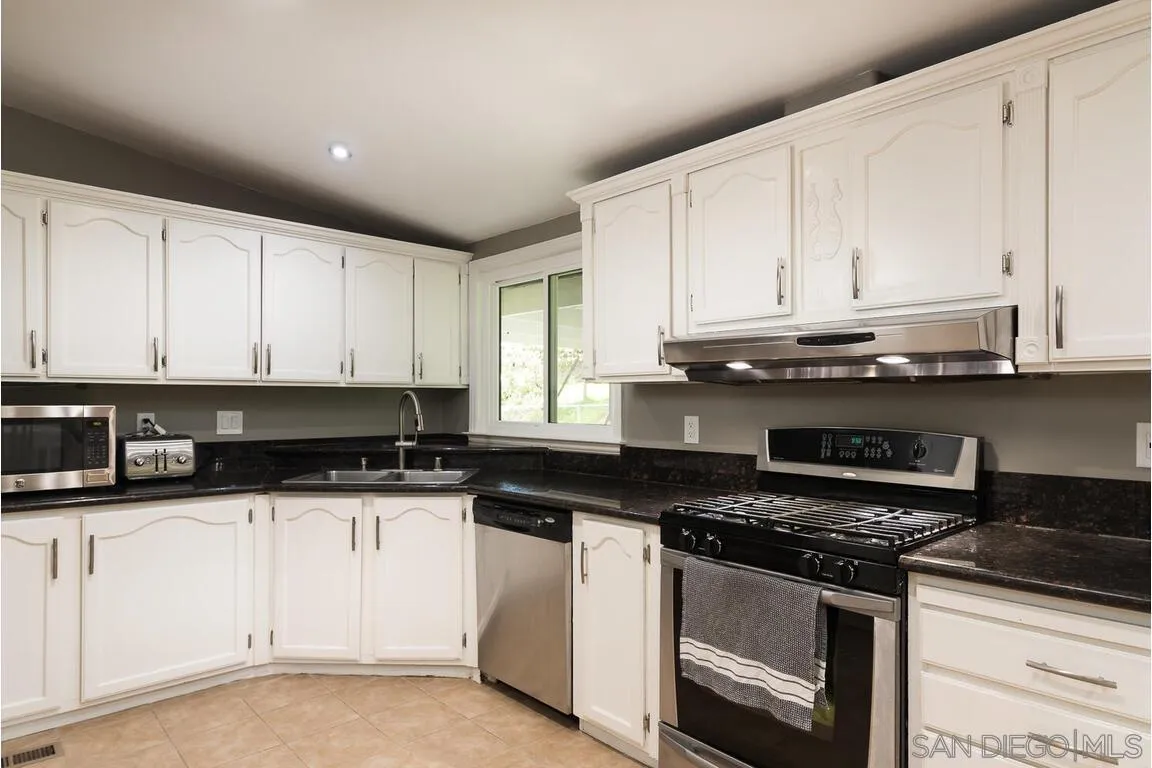 9399 Weber Court Spring Valley, CA 91977 - Photo 9 of 41 a kitchen with granite countertop a stove sink and cabinets