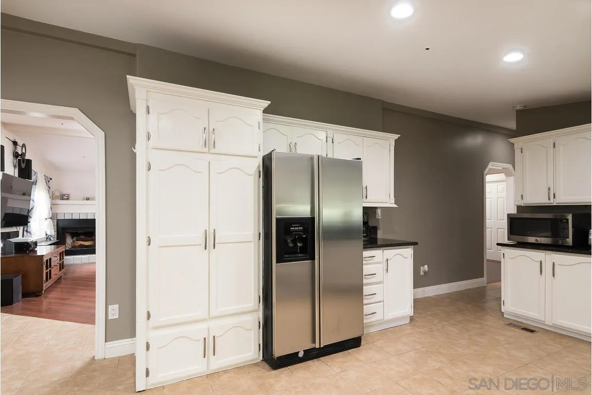 9399 Weber Court Spring Valley, CA 91977 - Photo 10 of 41 a kitchen with stainless steel appliances kitchen island granite countertop a refrigerator and a sink