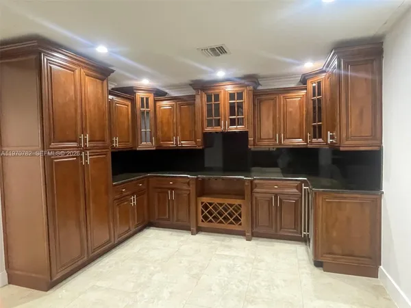 a large kitchen with stainless steel appliances granite countertop a refrigerator and a sink