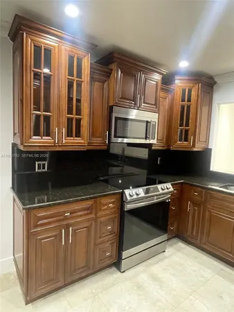 a kitchen with stainless steel appliances granite countertop a stove and a sink